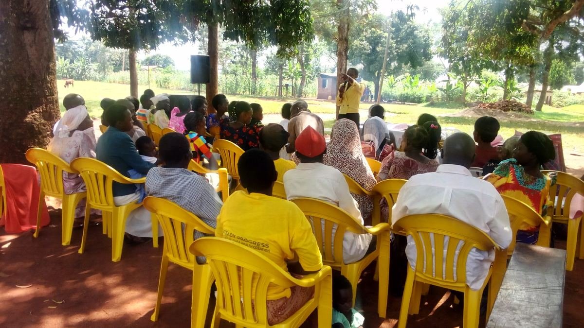 Community members seated outdoors at an outreach event