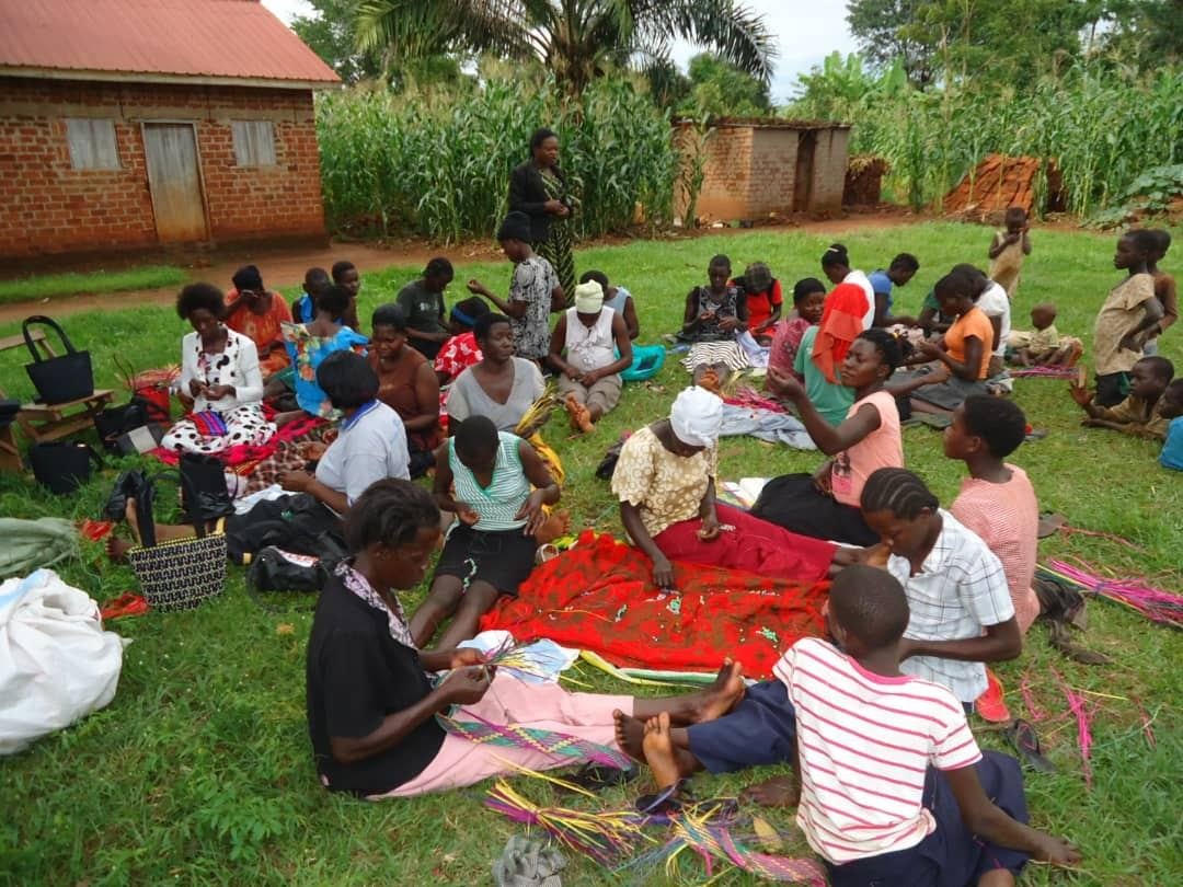 Women and girls learning craft skills together on the grass