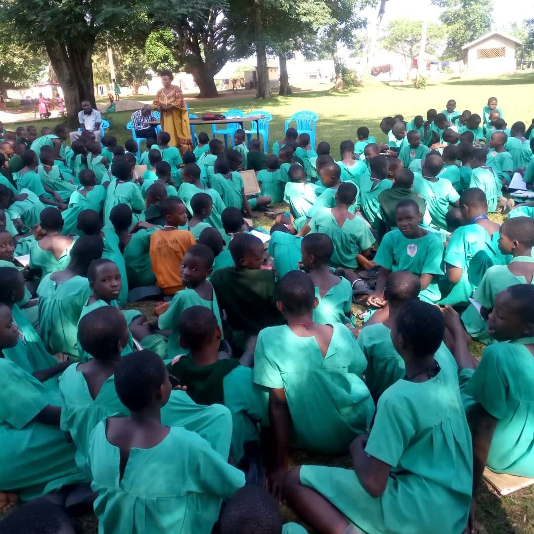 A large gathering of girls in green uniforms at a symposium